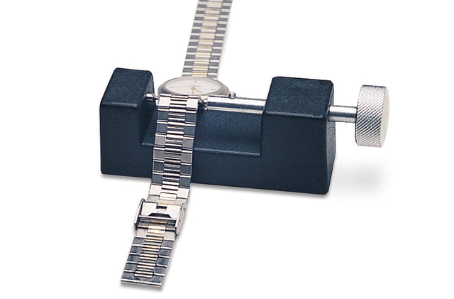 Watch bracelet secured in black holder tool with metal adjustment knob for repair